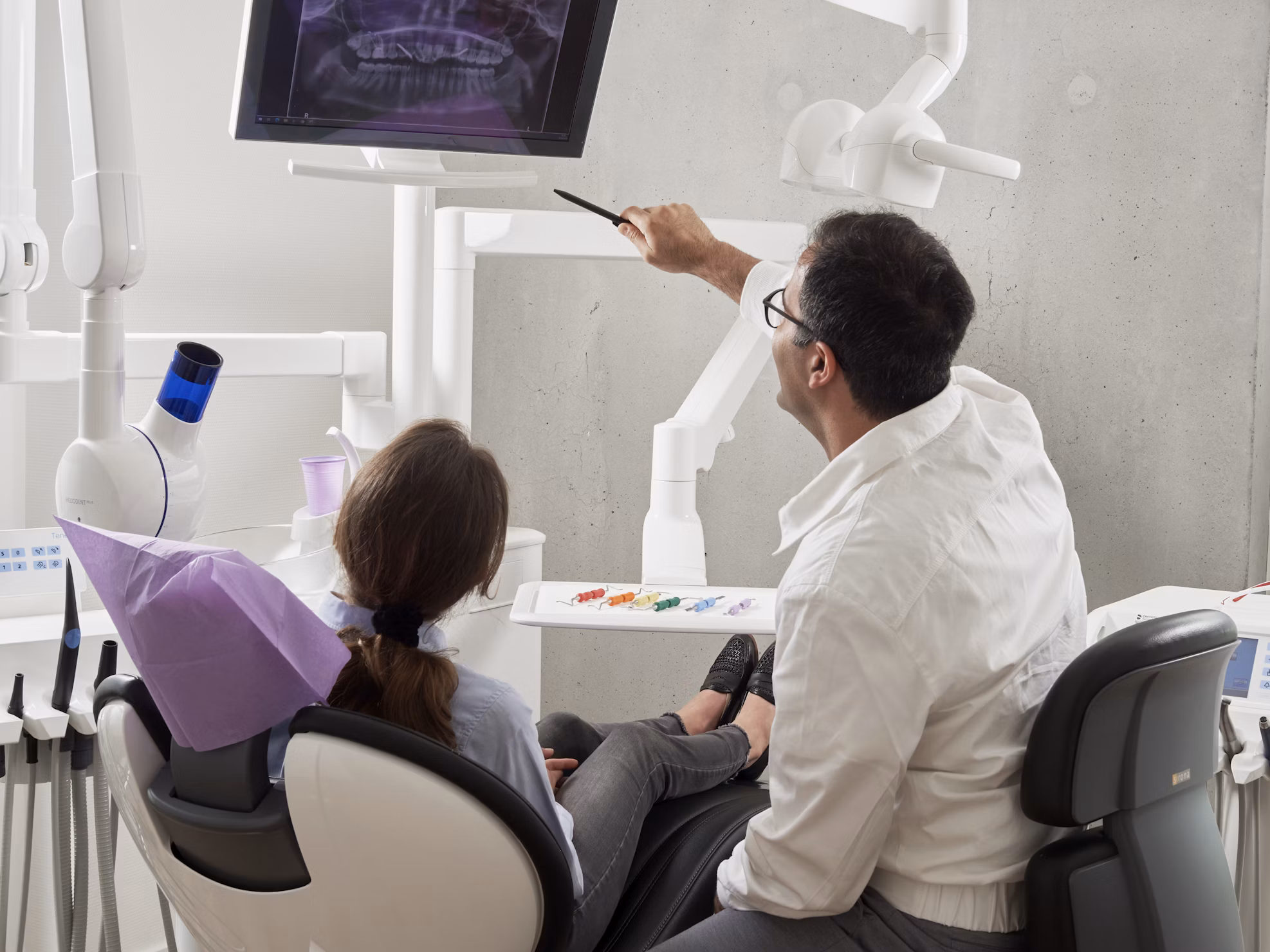Dentist explains dental X-ray to female patient in a modern clinic, highlighting oral health care and professional consultation. canadian dental care plan cdcp | cdcp dental | cdcp dental Plan